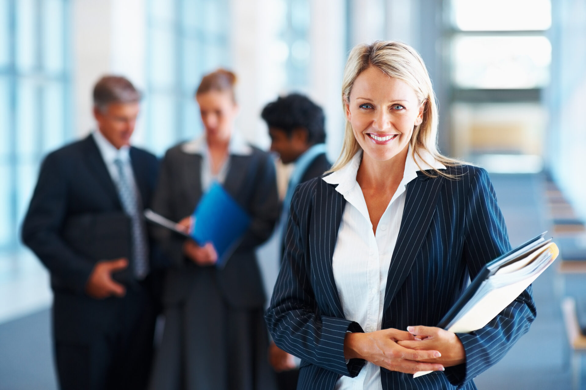 Happy businesswoman with colleagues in the background